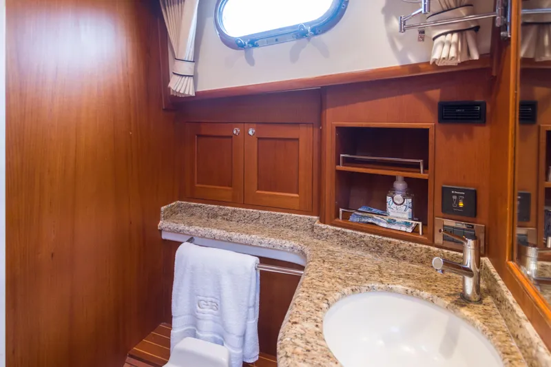 Slide: The Image of Luxurious bathroom in 2012 Grand Banks 46 Eastbay SX yacht with granite countertop and wooden cabinetry. - 12