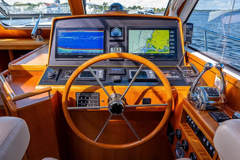 Slide: The Image of Helm of 2012 Grand Banks 46 Eastbay SX with navigation screens and wooden steering wheel. - 24