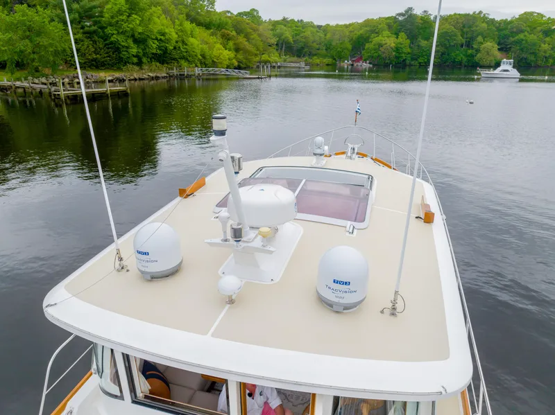 Slide: The Image of 2012 Grand Banks 46 Eastbay SX yacht on a serene river with lush greenery. - 35