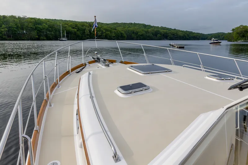 Slide: The Image of 2012 Grand Banks 46 Eastbay SX yacht on calm lake with lush green shoreline. - 37