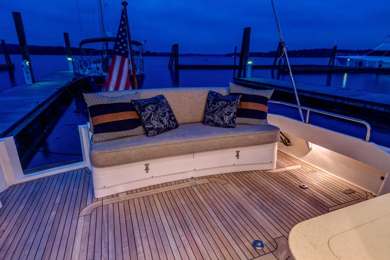 Slide: The Image of Luxury seating on 2012 Grand Banks 46 Eastbay SX yacht at dusk, docked by the water. - 44