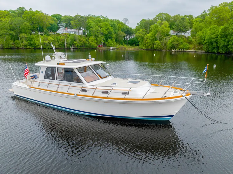 Slide: The Image of 2012 Grand Banks 46 Eastbay SX yacht on a serene lake with lush greenery. - 49