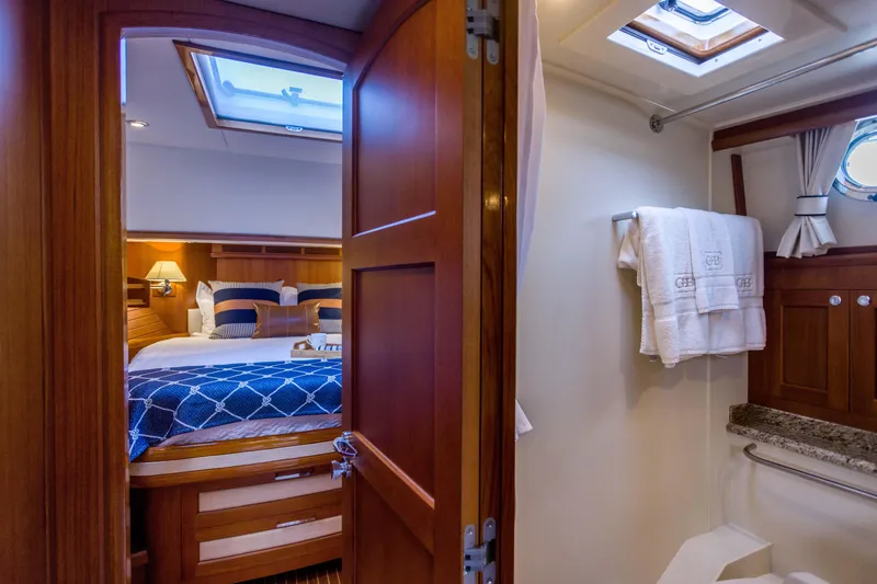 Slide: The Image of Luxurious cabin interior of 2012 Grand Banks 46 Eastbay SX yacht, featuring cozy bedroom and bathroom. - 7