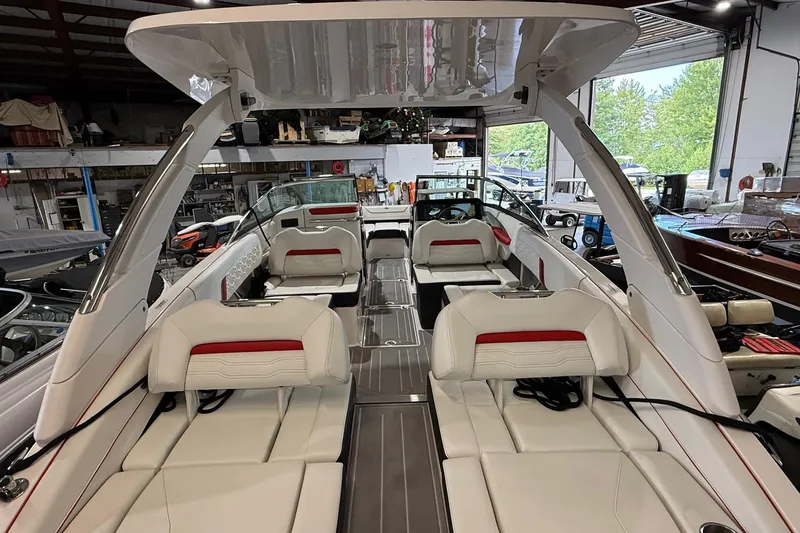Slide: The Image of 2024 Regal LS6 boat interior with white and red seating in a showroom. - 13