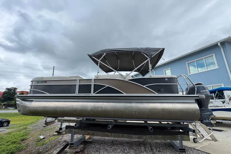 Slide: The Image of 2017 Sweetwater Premium Edition 255 SL pontoon boat on display, overcast sky background. - 9