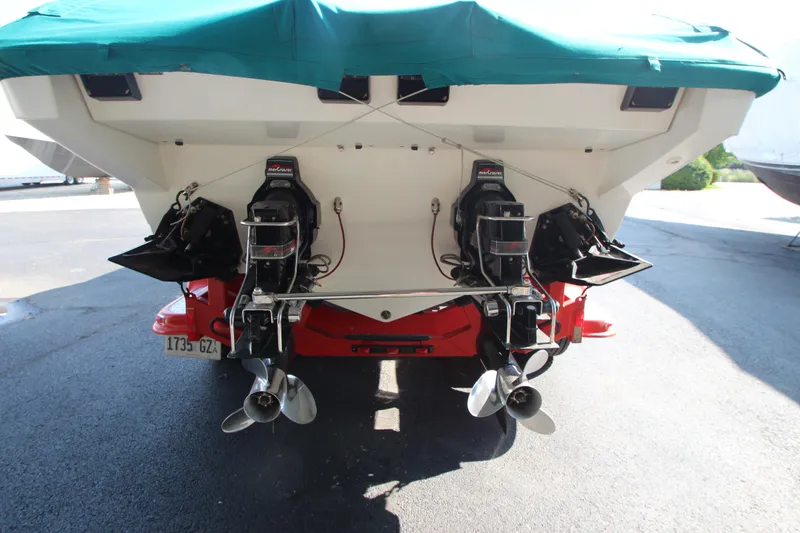 Slide: The Image of 1995 Formula SR1 303 boat with dual outboard motors, covered in green tarp. - 2