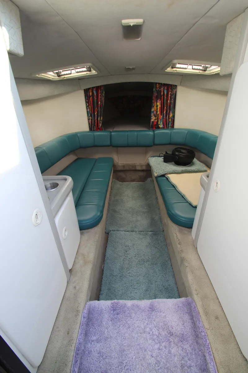 Slide: The Image of Interior of 1995 Formula SR1 303 boat with teal seating and colorful curtains. - 22
