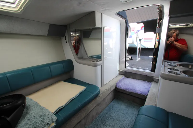 Slide: The Image of 1995 Formula SR1 303 boat interior with teal seating and compact cabin layout. - 25