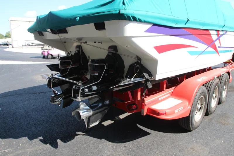 Slide: The Image of 1995 Formula SR1 303 boat on trailer, covered, with vibrant graphics and dual propellers. - 3