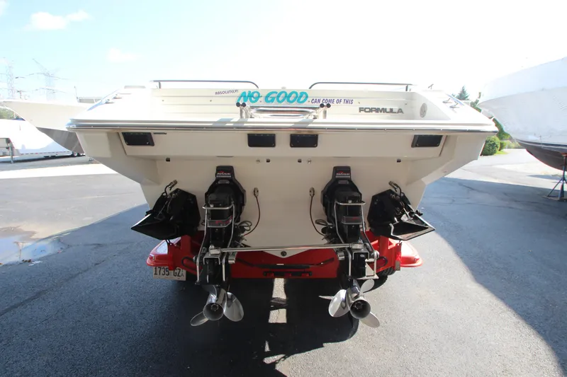 Slide: The Image of 1995 Formula SR1 303 boat with dual outboard motors, parked on a sunny day. - 33