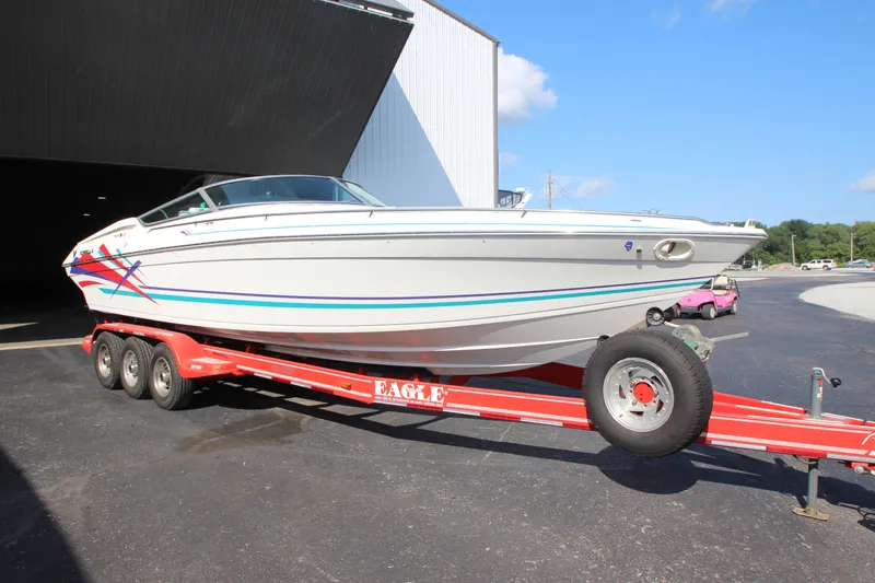 Slide: The Image of 1995 Formula SR1 303 boat on red trailer outside a building. - 7