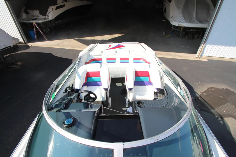 Slide: The Image of 1995 Formula SR1 303 speedboat with colorful interior, parked in a garage. - 9