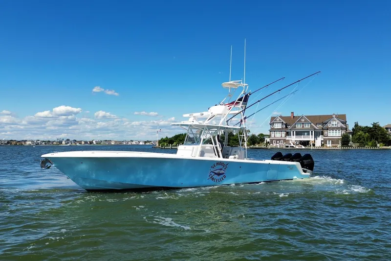 Slide: The Image of 2018 SeaVee 390Z boat cruising on a sunny day near waterfront homes. - 1
