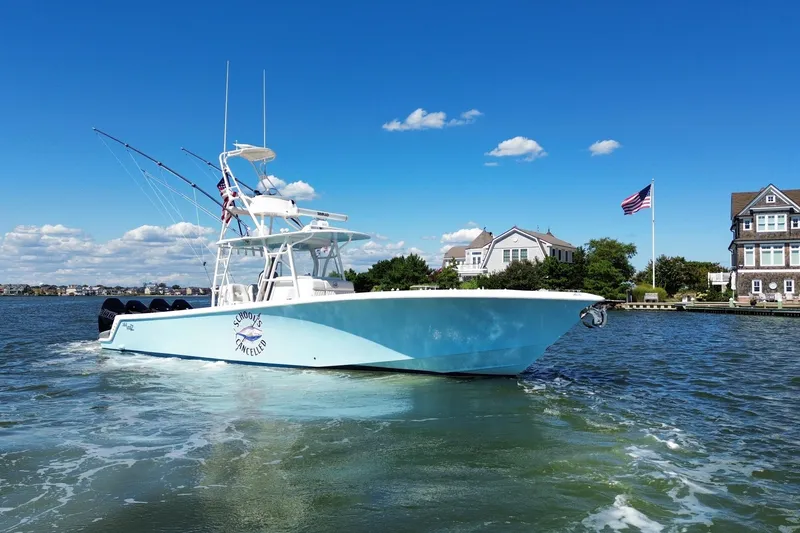 Slide: The Image of 2018 SeaVee 390Z boat cruising on a sunny day near waterfront homes. - 11