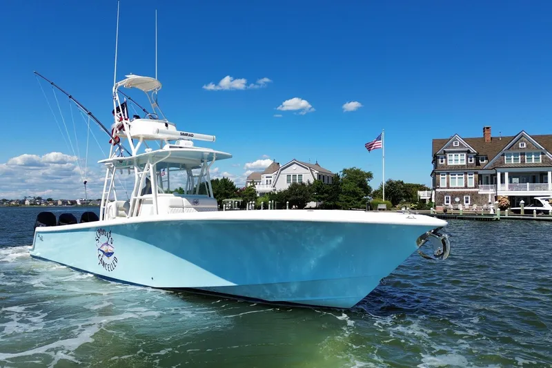 Slide: The Image of 2018 SeaVee 390Z boat cruising near waterfront homes under a clear blue sky. - 12