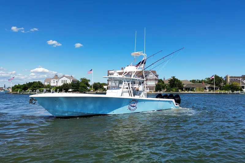 Slide: The Image of 2018 SeaVee 390Z boat cruising on a sunny day near waterfront homes. - 14