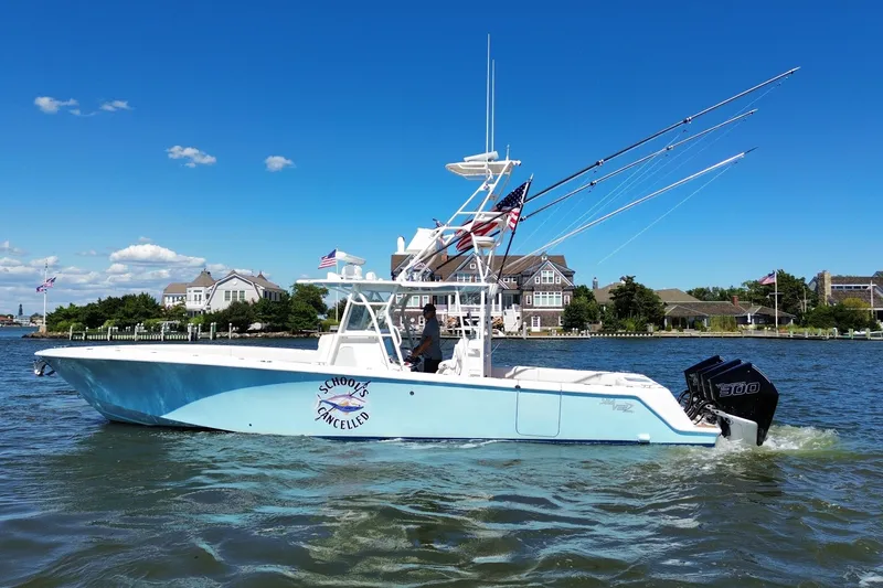 Slide: The Image of 2018 SeaVee 390Z boat on water, clear sky, waterfront homes in background. - 15