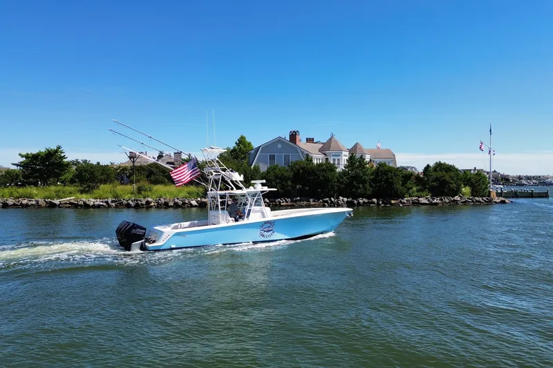 Slide: The Image of 2018 SeaVee 390Z boat cruising on a sunny day near waterfront homes. - 19