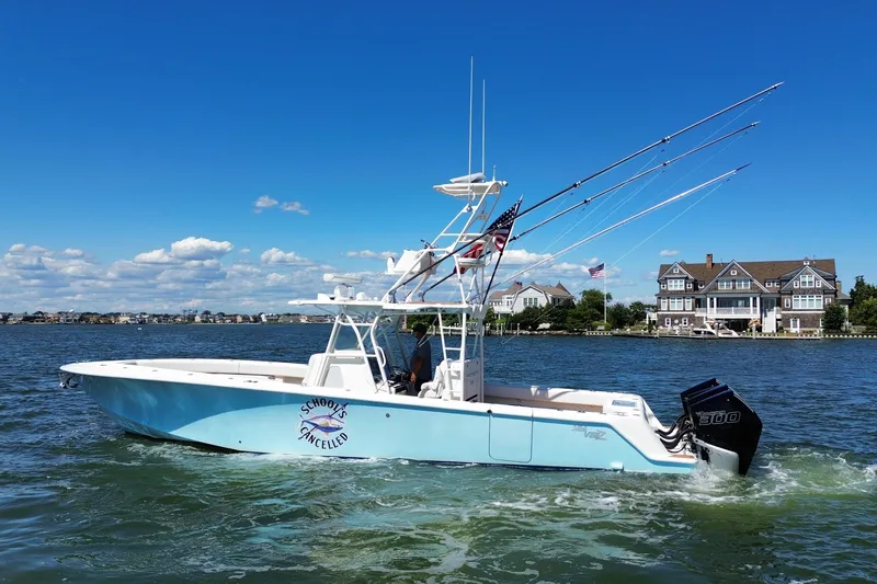 Slide: The Image of 2018 SeaVee 390Z boat cruising on a sunny day near waterfront homes. - 2