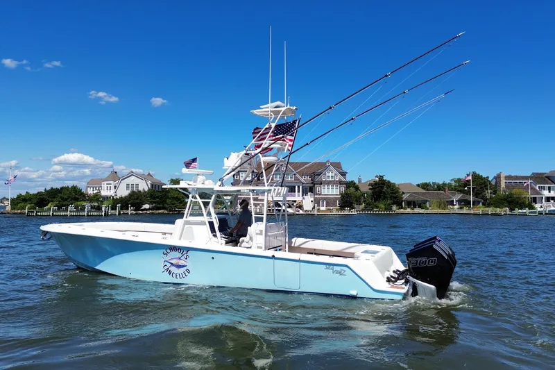 Slide: The Image of 2018 SeaVee 390Z boat on water, fishing rods, American flag, coastal homes in background. - 3