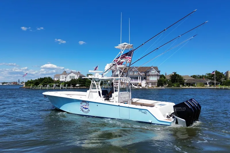 Slide: The Image of 2018 SeaVee 390Z boat on water, fishing rods, American flag, coastal homes in background. - 4