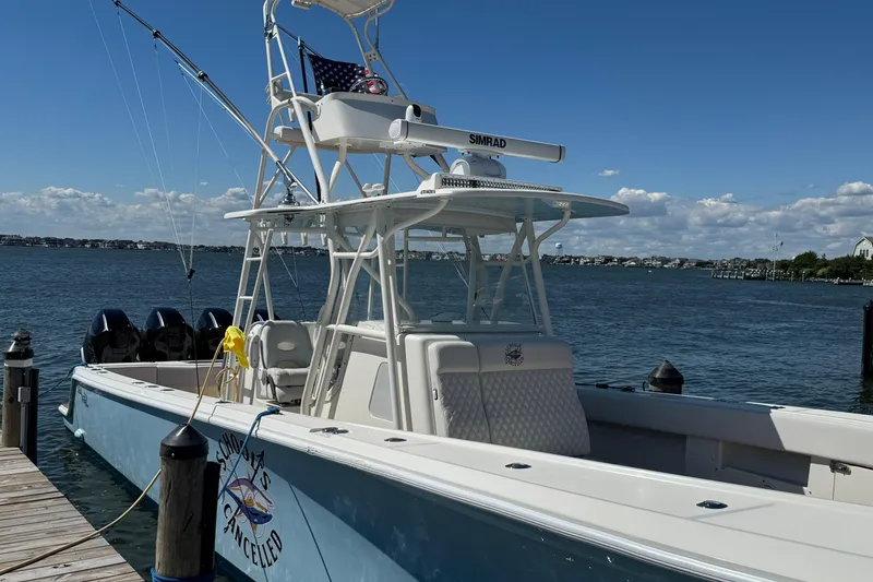 Slide: The Image of 2018 SeaVee 390Z boat docked by the water, featuring a tower and multiple engines. - 46