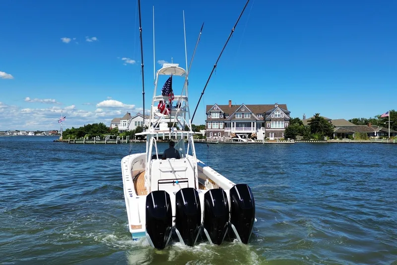 Slide: The Image of 2018 SeaVee 390Z boat with four engines cruising near waterfront homes under a clear blue sky. - 5