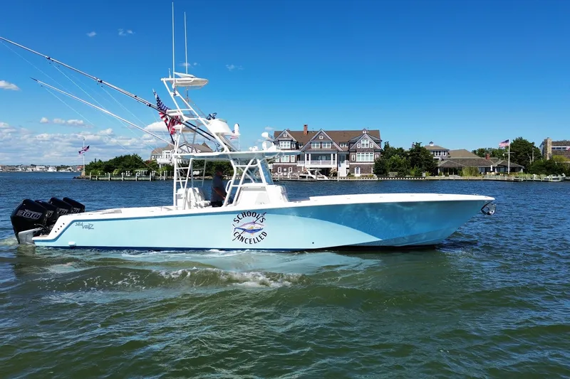 Slide: The Image of 2018 SeaVee 390Z boat cruising on a sunny day near waterfront homes. - 7