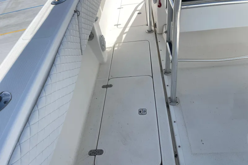 Slide: The Image of 2002 Fountain 38 CC Tournament Edition boat deck with storage compartments and padded railing. - 19