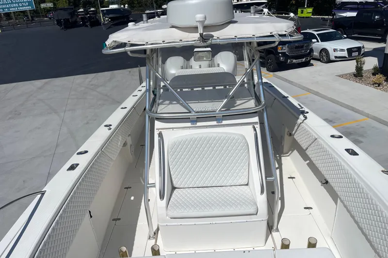 Slide: The Image of 2002 Fountain 38 CC Tournament Edition boat with white seating and T-top in a parking lot. - 23