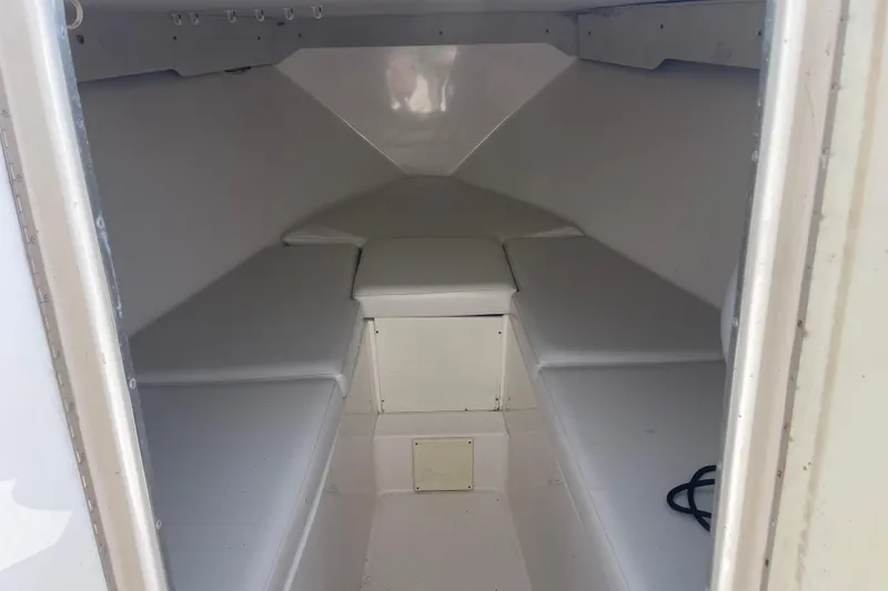 Slide: The Image of 2002 Fountain 38 CC Tournament Edition boat cabin interior with white cushioned seating. - 24