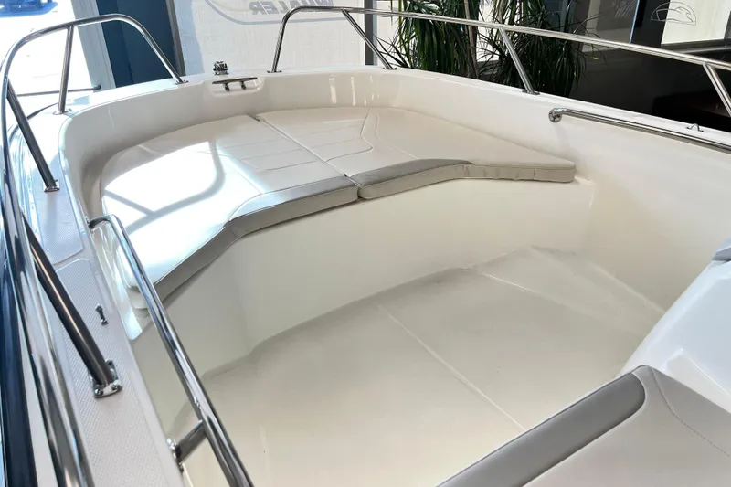 Slide: The Image of 2026 Boston Whaler 160 Super Sport boat interior with cushioned seating and stainless steel railings. - 5