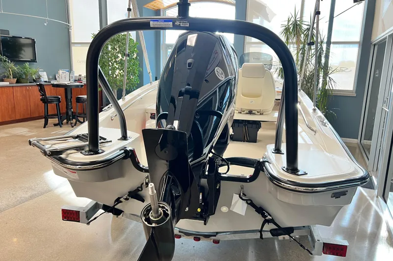 Slide: The Image of 2026 Boston Whaler 160 Super Sport boat displayed indoors, rear view with motor. - 7