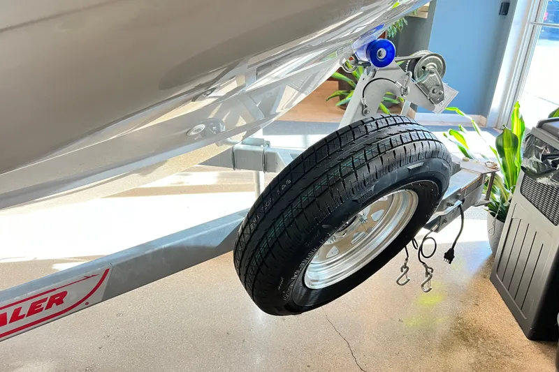 Slide: The Image of 2026 Boston Whaler 160 Super Sport trailer with spare tire in showroom. - 8