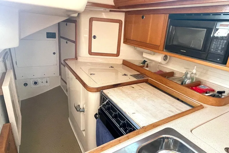 Slide: The Image of Interior of 2001 Catalina 42 sailboat kitchen with stove, sink, and microwave. - 10