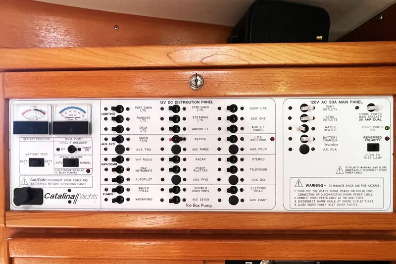 Slide: The Image of Electrical control panel of a 2001 Catalina 42 yacht, featuring various switches and gauges. - 12