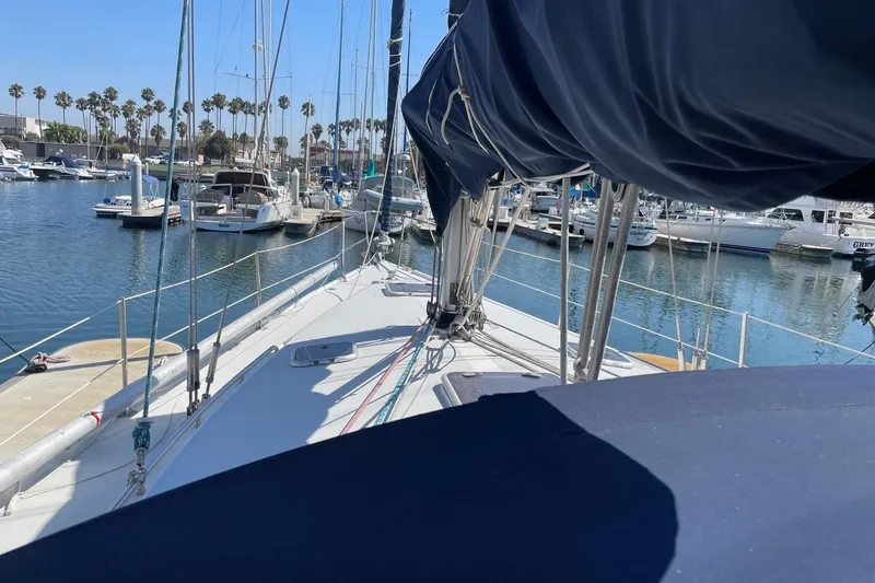 Slide: The Image of Sailboat Catalina 42, 2001 model, docked in a sunny marina with palm trees. - 27