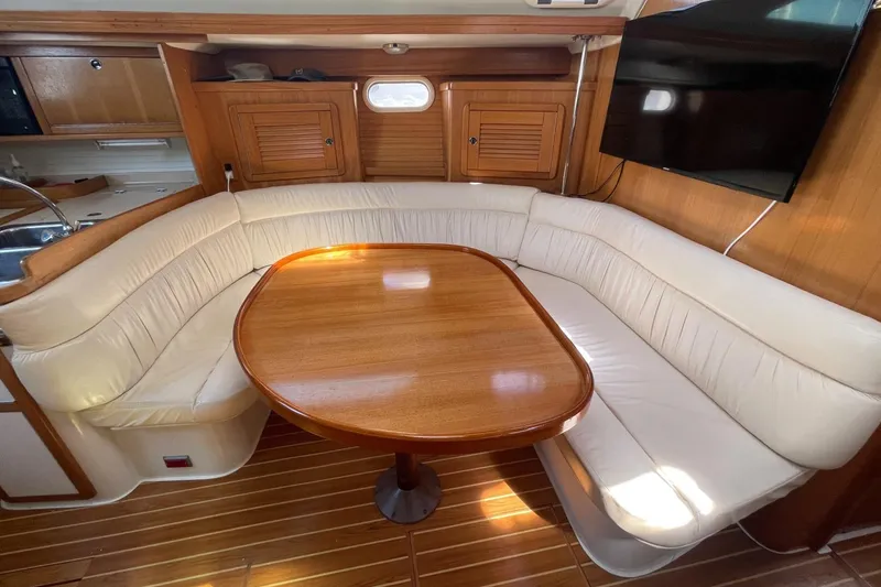 Slide: The Image of Luxurious interior of 2001 Catalina 42 yacht with wooden table and plush seating. - 3