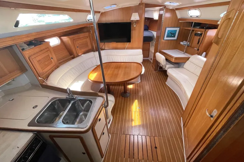 Slide: The Image of Interior of 2001 Catalina 42 sailboat with wood finish, seating, and kitchenette. - 6