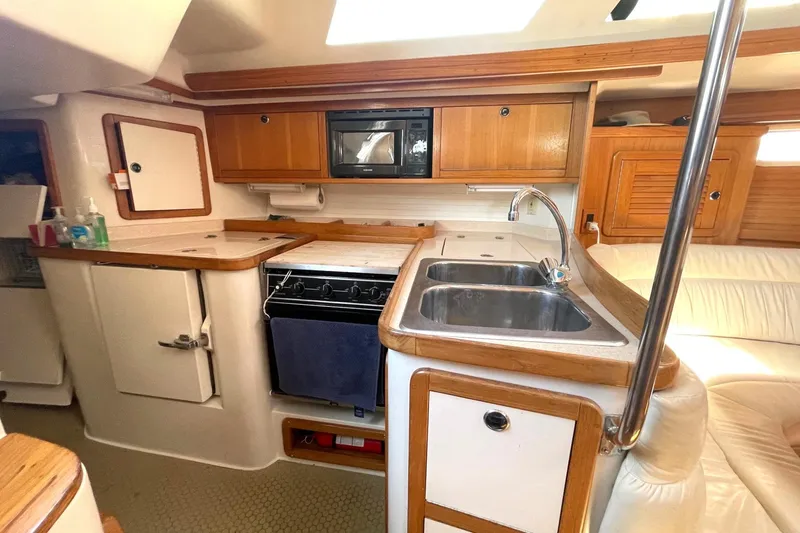 Slide: The Image of Interior of 2001 Catalina 42 sailboat kitchen with sink, stove, and wooden cabinetry. - 9