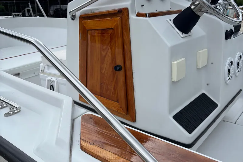 Slide: The Image of 1996 Boston Whaler 21 Outrage boat console with wood accents and steering wheel. - 12