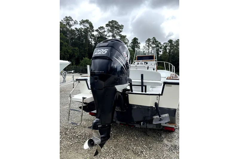 Slide: The Image of 1996 Boston Whaler 21 Outrage boat with Mercury 225 outboard motor, parked outdoors. - 4