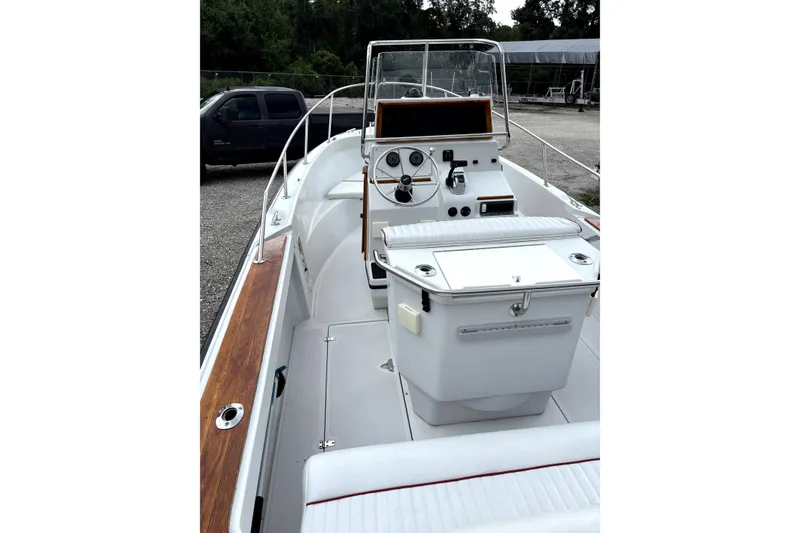 Slide: The Image of 1996 Boston Whaler 21 Outrage boat interior with console and seating, parked outdoors. - 8