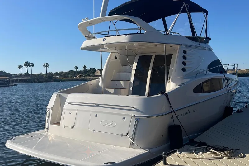 Slide: The Image of 2002 Regal Commodore 3880 yacht docked by a scenic waterfront. - 10