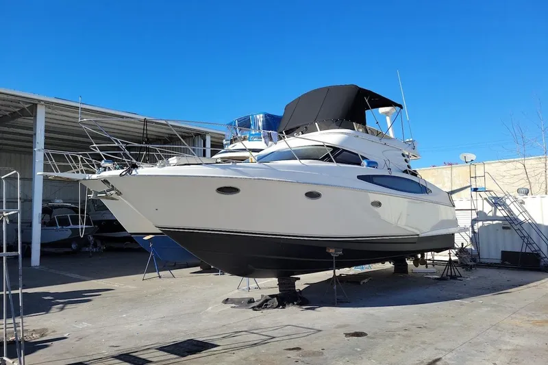 Slide: The Image of 2002 Regal Commodore 3880 yacht on dry dock under clear blue sky. - 11
