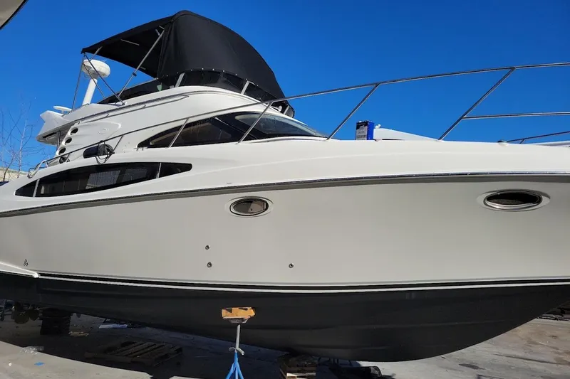 Slide: The Image of 2002 Regal Commodore 3880 yacht with sleek design and black canopy against blue sky. - 12