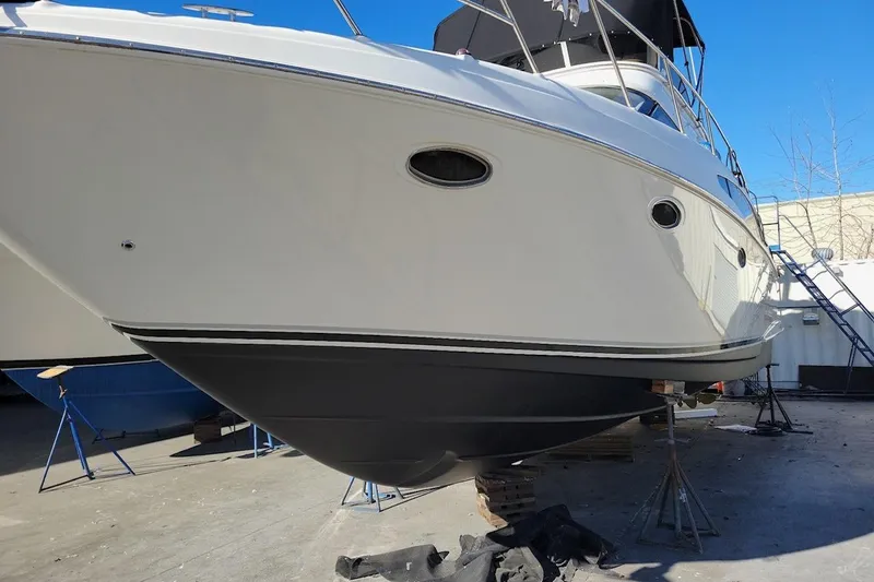 Slide: The Image of 2002 Regal Commodore 3880 yacht on dry dock, showcasing sleek hull design. - 13