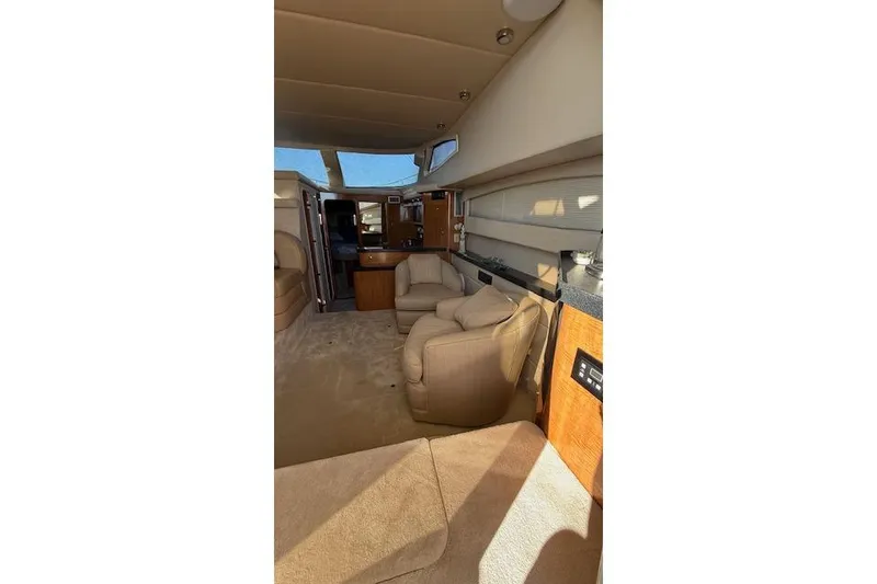Slide: The Image of Interior of 2002 Regal Commodore 3880 yacht with beige seating and wooden cabinetry. - 26