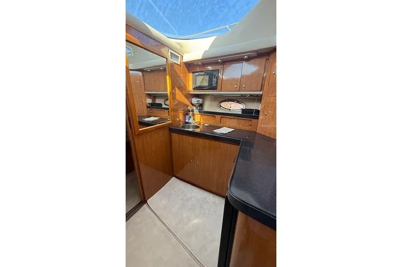 Slide: The Image of Luxurious 2002 Regal Commodore 3880 yacht interior kitchen with wood cabinetry and modern amenities. - 29