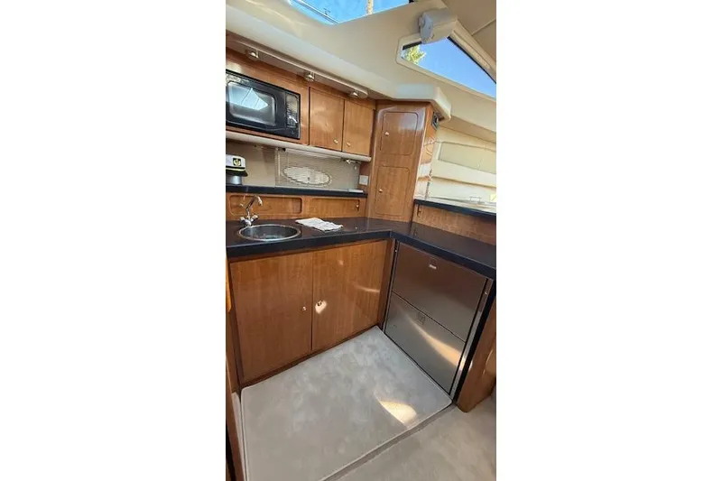Slide: The Image of Interior of 2002 Regal Commodore 3880 yacht kitchen with wood cabinets and appliances. - 30